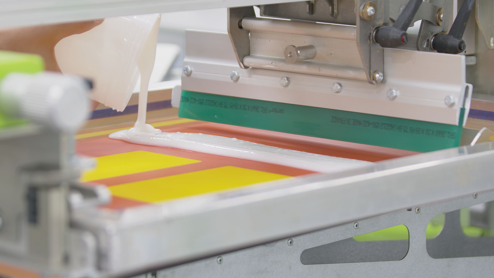 Pouring ink onto a screen printing machine