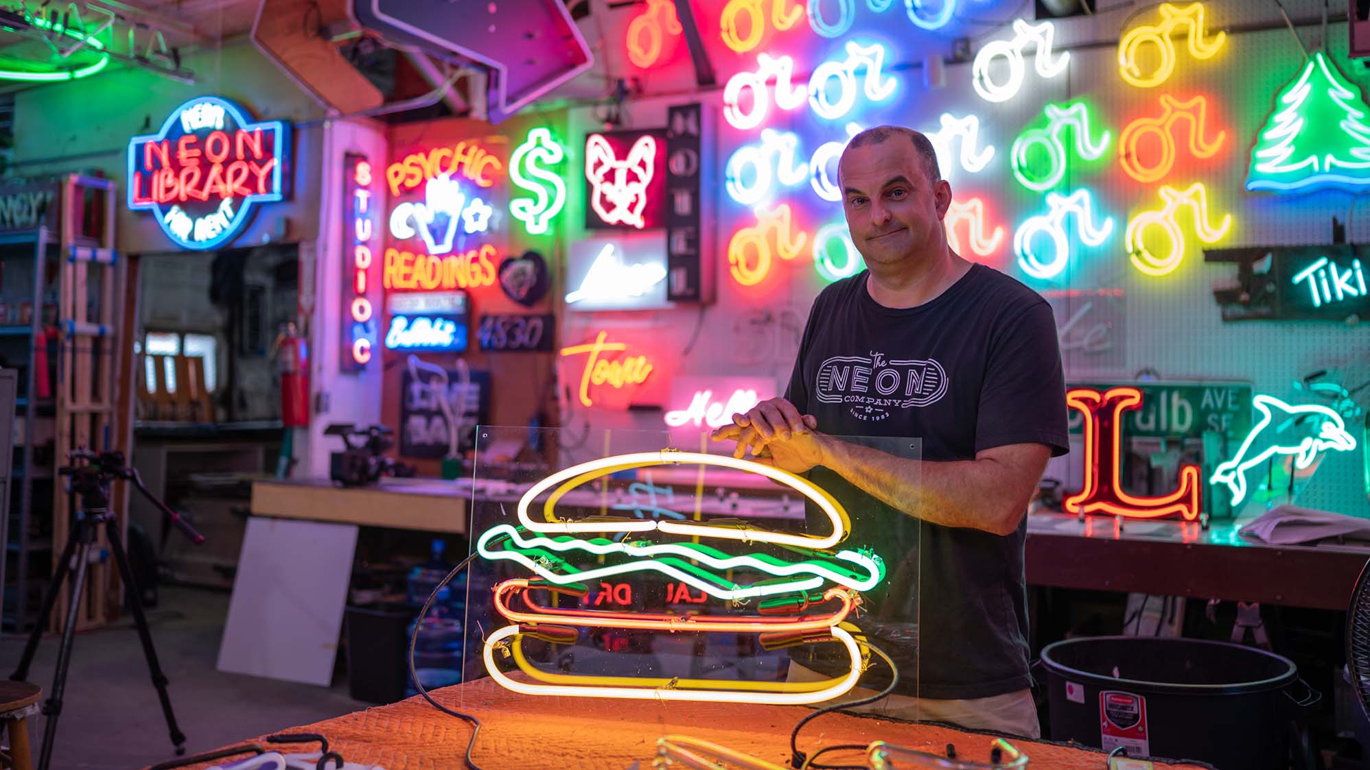 Man with neon sign of a hamburger
